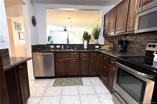 a kitchen with stainless steel appliances granite countertop a stove a sink and a microwave