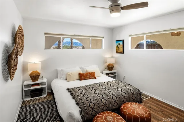 a bedroom with a bed wooden floor and dresser