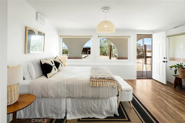 a bedroom with a bed and painting on the wall