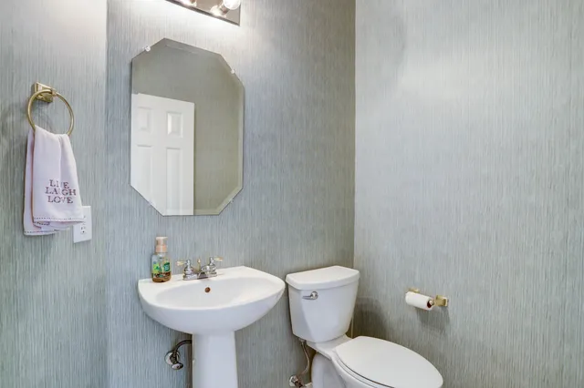 a bathroom with a toilet sink and mirror