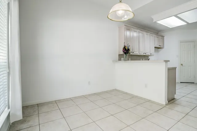 a view of an empty room with a chandelier fan