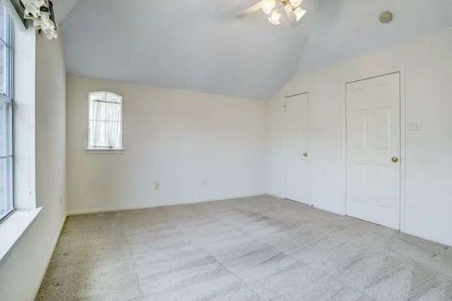 an empty room with a chandelier fan