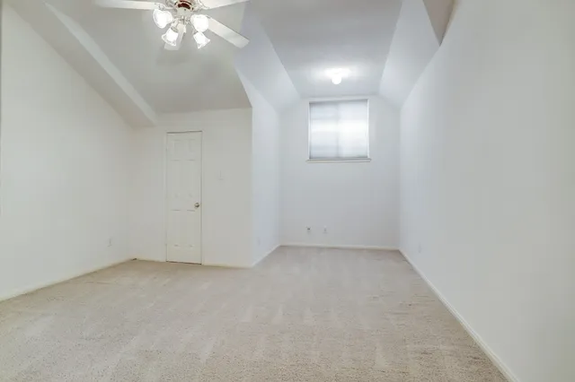 a view of an empty room with a chandelier fan