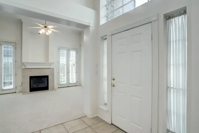 a view of a livingroom with a fireplace cabinet and a chandelier fan