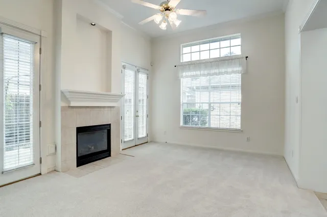 an empty room with windows and fireplace
