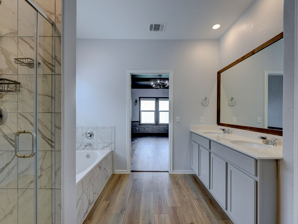 1716 Frontenac Street Leander, TX 78641 - Photo 24 of 34 a bathroom with a double vanity sink toilet and shower