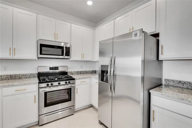 a kitchen with cabinets stainless steel appliances and a counter space
