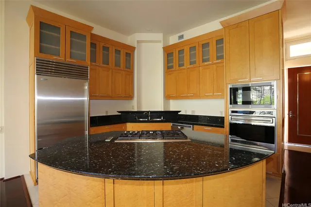a kitchen with a refrigerator and a stove top oven