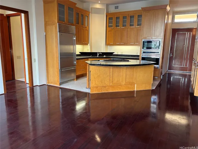 a kitchen with stainless steel appliances granite countertop a refrigerator a stove and a wooden floors