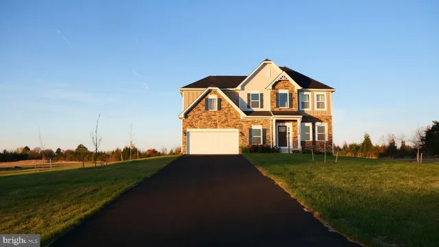 a view of a big house with a big yard and large trees