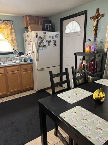 a kitchen with a table chairs and refrigerator