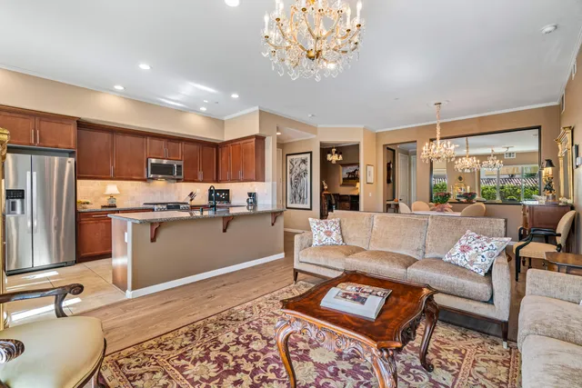 a living room with a couch and a dining table with kitchen view