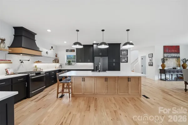 a kitchen with stainless steel appliances kitchen island granite countertop a stove a sink and a refrigerator