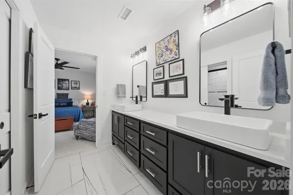a spacious en suite bathroom with a double vanity sink and a mirror