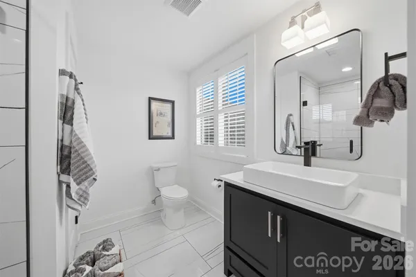 a bathroom with a sink a toilet and a mirror