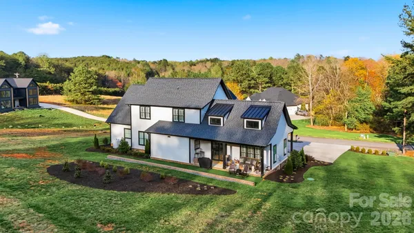 a aerial view of a house next to a big yard and large trees