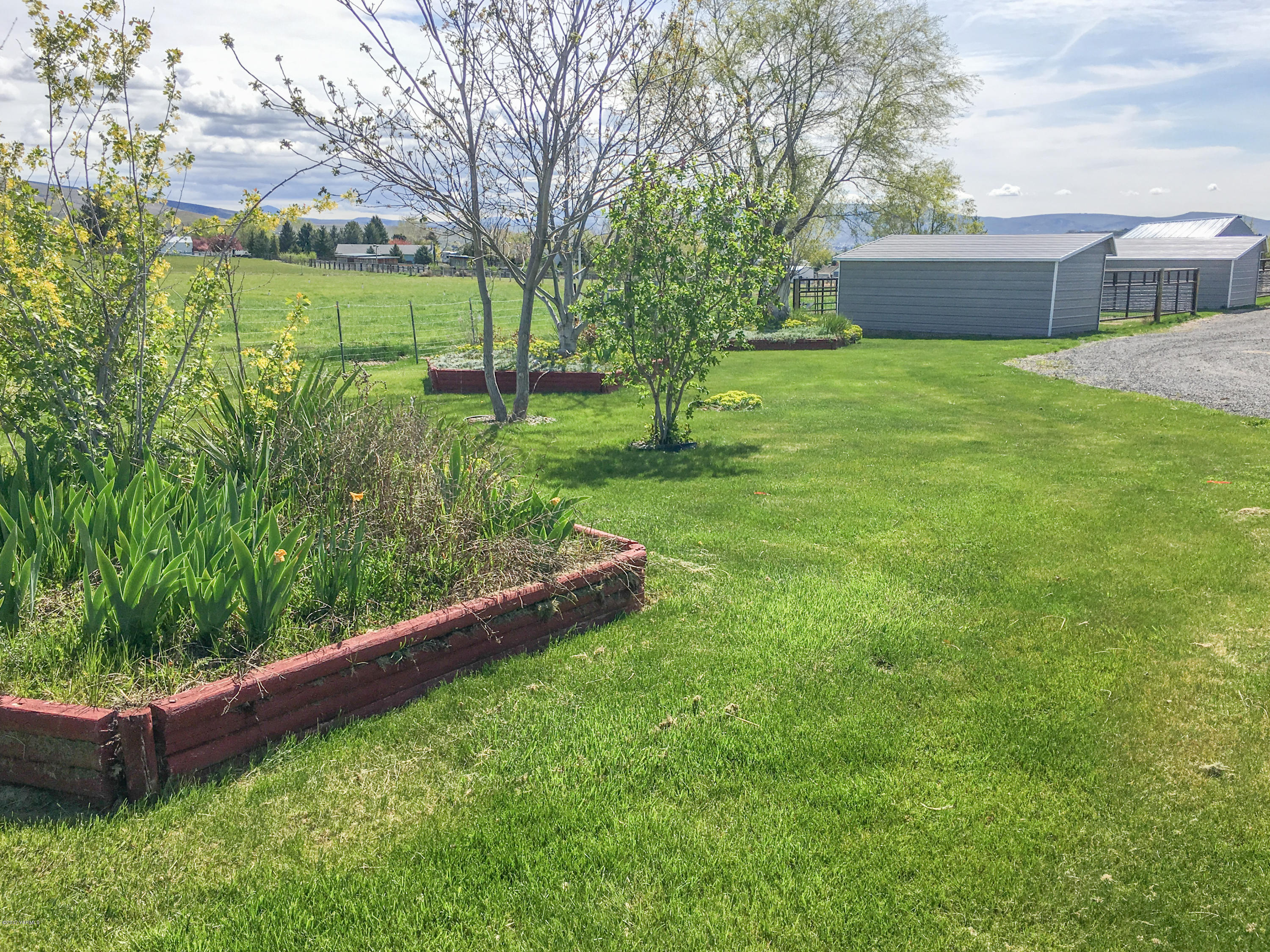 331 Sheep Company Road Selah, WA 98942 - Photo 27 of 40 a view of a backyard with a garden and plants
