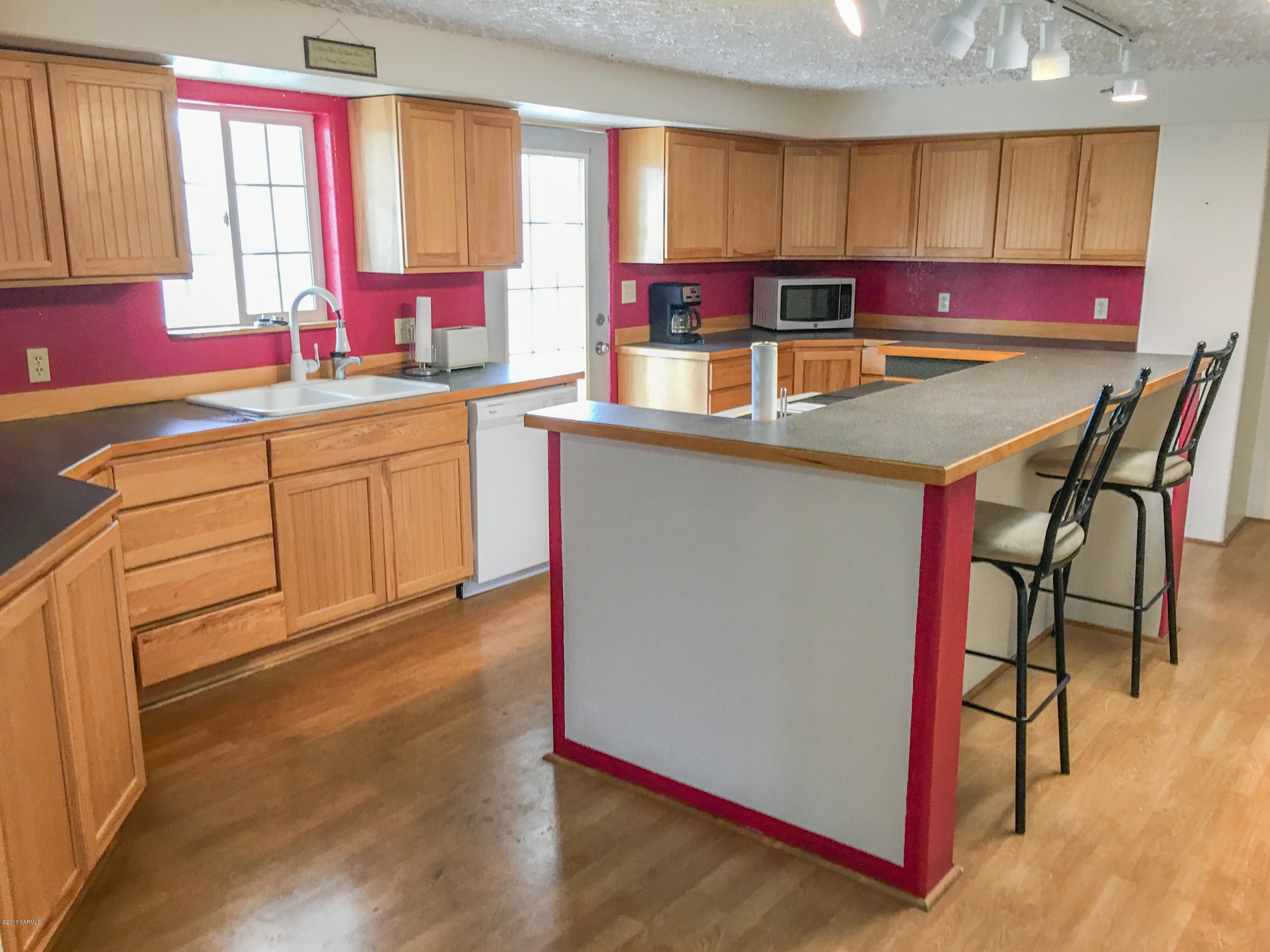331 Sheep Company Road Selah, WA 98942 - Photo 8 of 40 a kitchen with kitchen island granite countertop wooden cabinets and white appliances