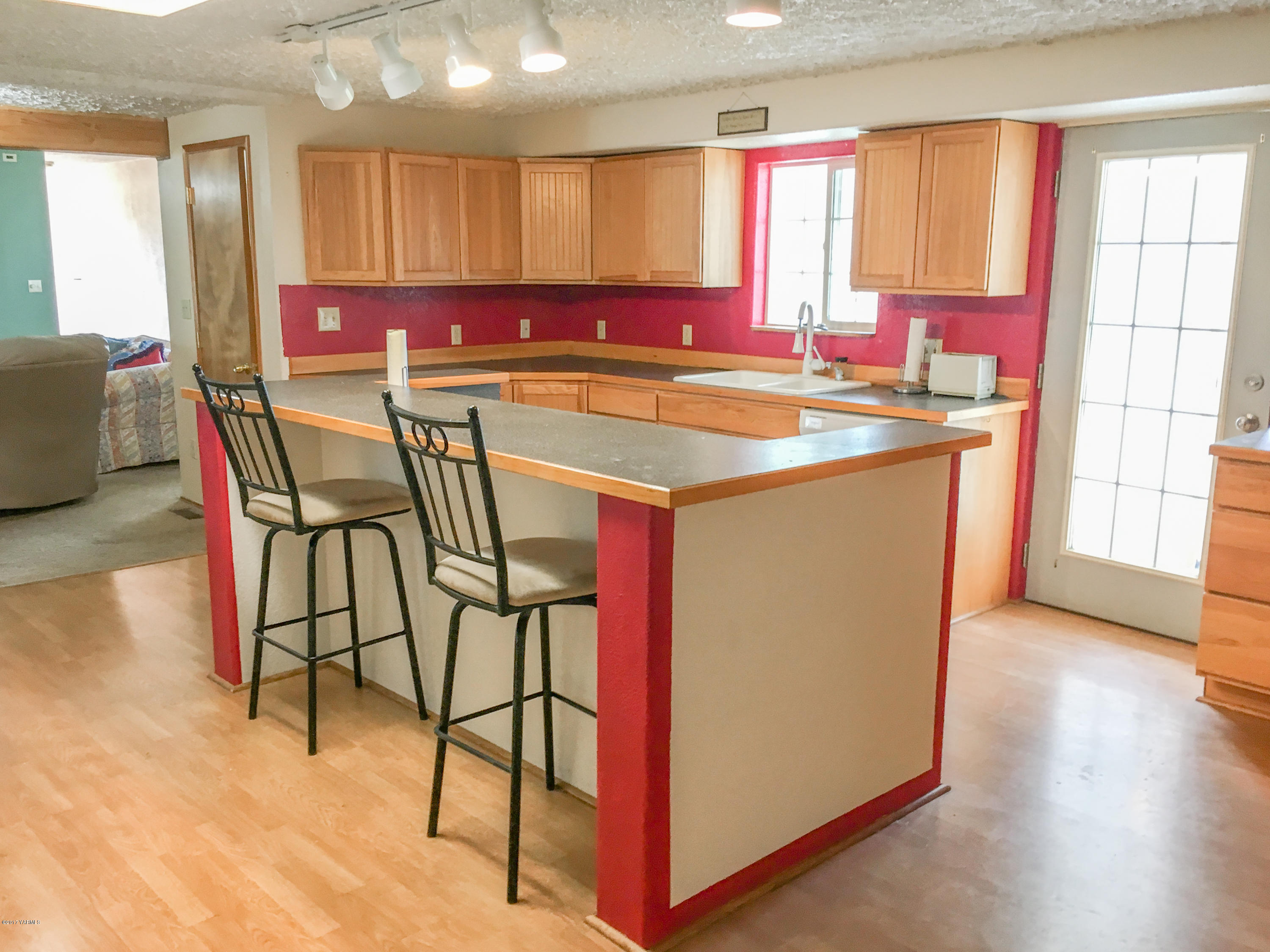 331 Sheep Company Road Selah, WA 98942 - Photo 9 of 40 a kitchen with stainless steel appliances granite countertop a stove top oven a sink a dining table and chairs with wooden floor