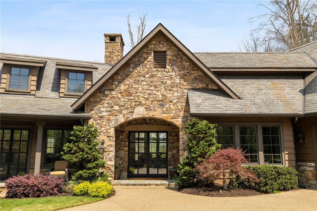 195 Village View Drive Sunset, SC 29685 - Photo 3 of 48 This charming home showcases a stone facade and a grand arched entryway, surrounded by lush landscaping.