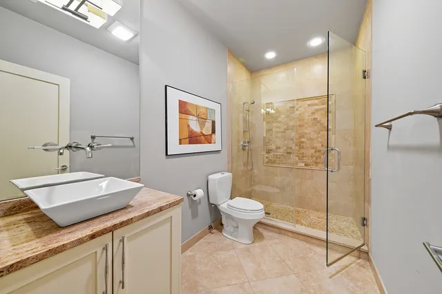 a bathroom with a granite countertop sink a toilet and shower