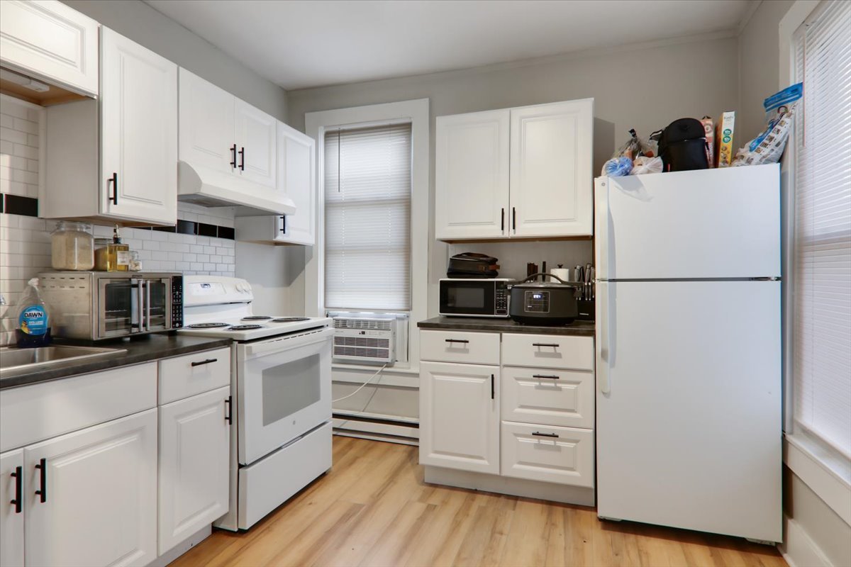 910 North Center Street Bloomington, IL 61701 - Photo 19 of 26 a kitchen with white cabinets and white appliances
