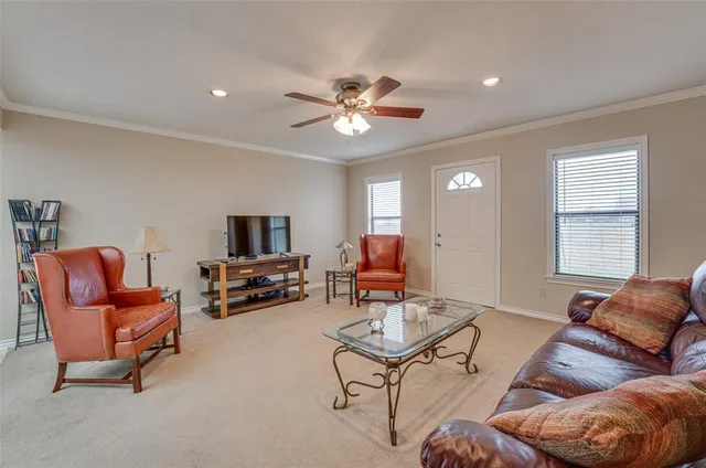 a living room with furniture and a flat screen tv with kitchen view