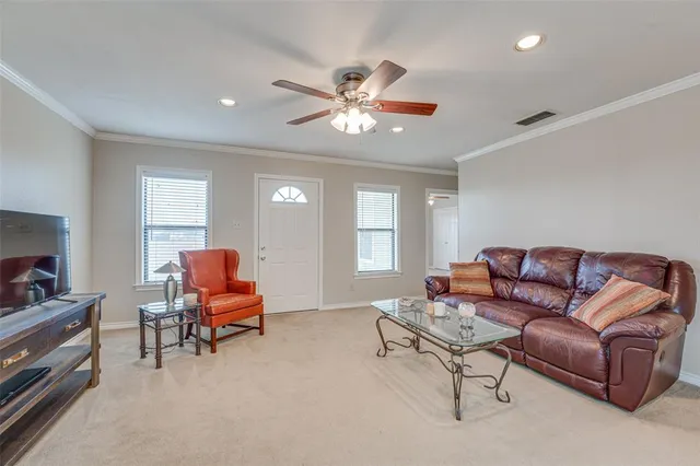 a living room with furniture and a ceiling fan