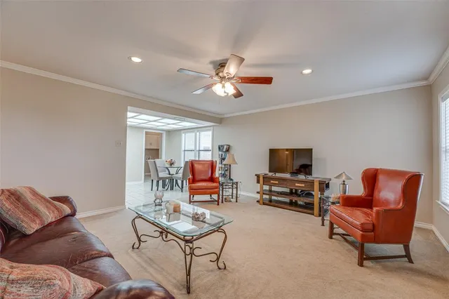 a living room with furniture and a flat screen tv with kitchen view