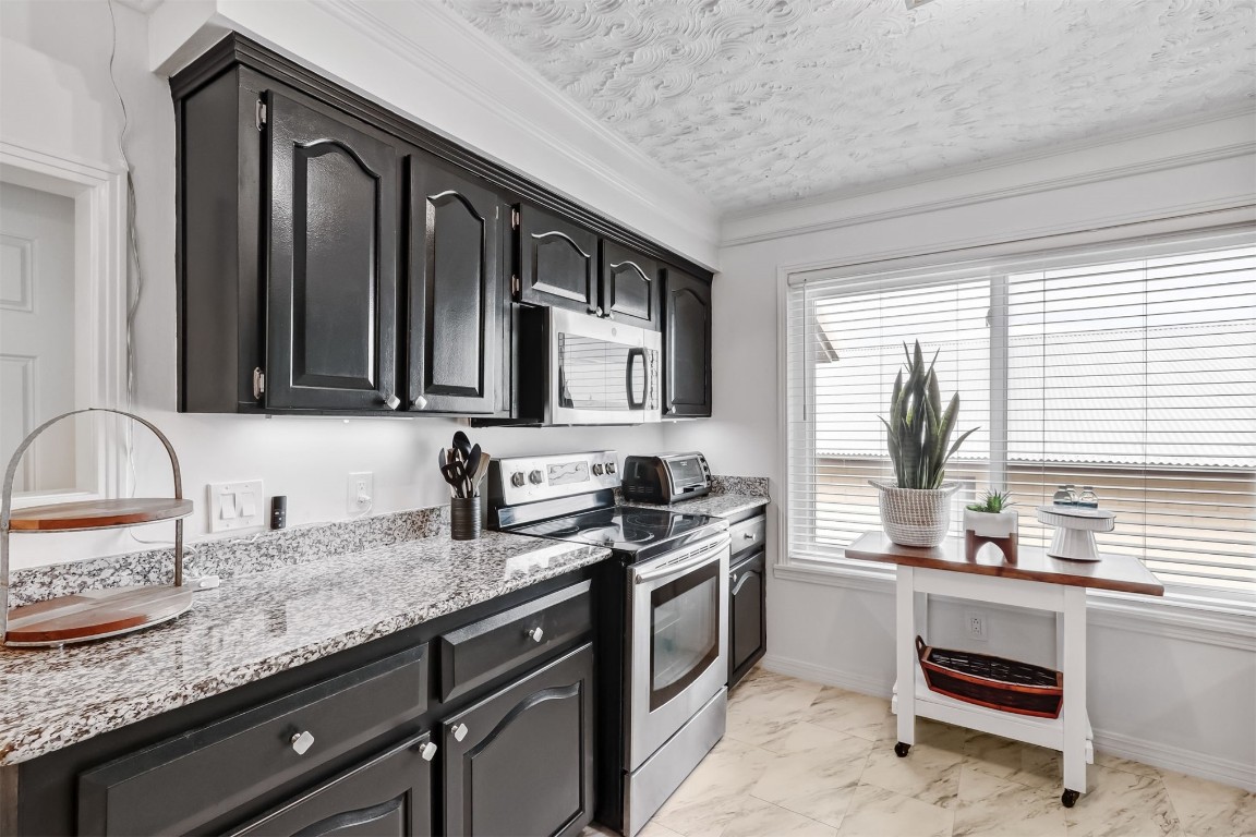 338 Tarpon Avenue Fernandina Beach, FL 32034 - Photo 13 of 36 a kitchen with granite countertop stainless steel appliances a sink stove refrigerator and cabinets
