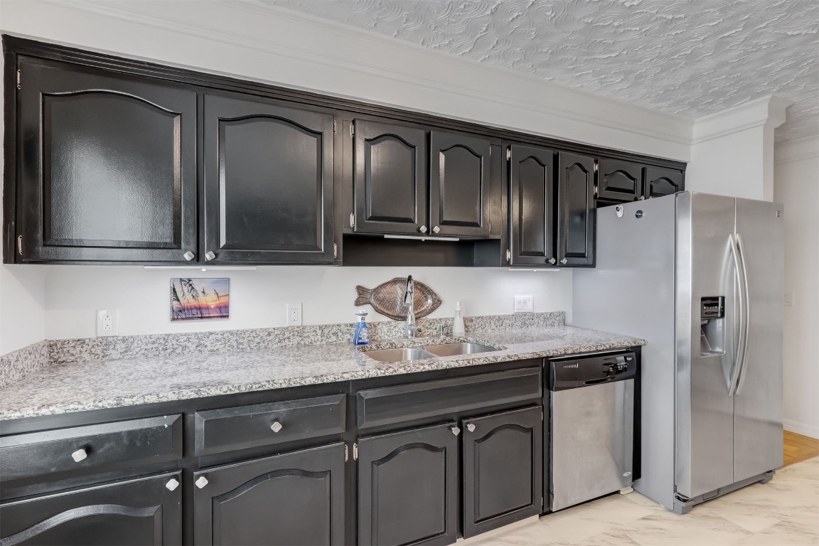 338 Tarpon Avenue Fernandina Beach, FL 32034 - Photo 15 of 36 a kitchen with granite countertop stainless steel appliances a sink and refrigerator