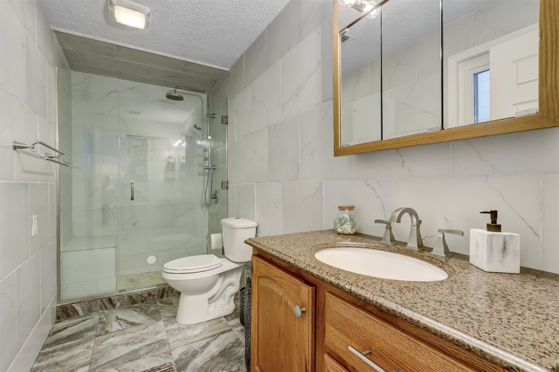 338 Tarpon Avenue Fernandina Beach, FL 32034 - Photo 19 of 36 a bathroom with a granite countertop sink toilet and shower