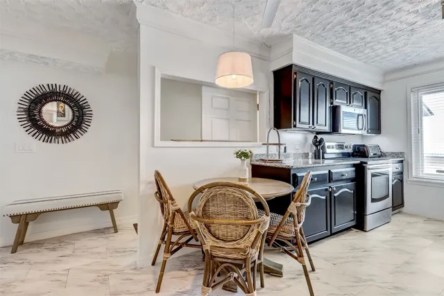 a kitchen with kitchen island granite countertop a sink stainless steel appliances cabinets and a counter top space