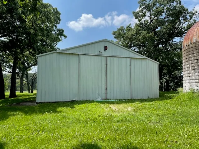 a view of backyard with potted plants and large tree