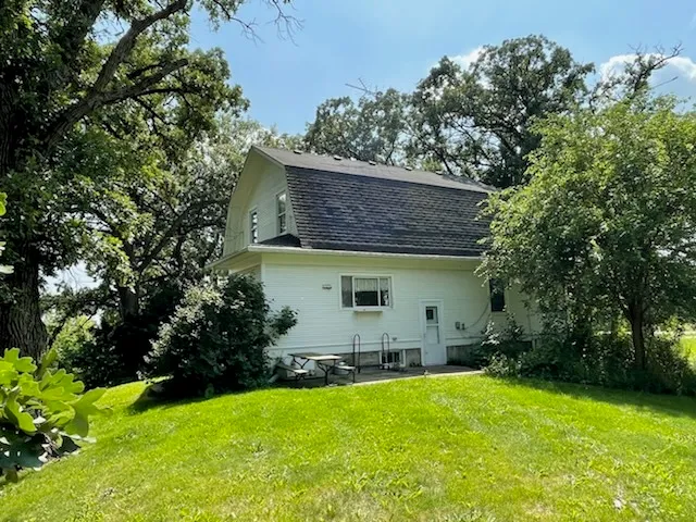 a backyard of a house with table and chairs