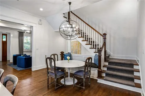 a view of a dining room with furniture a chandelier and wooden floor