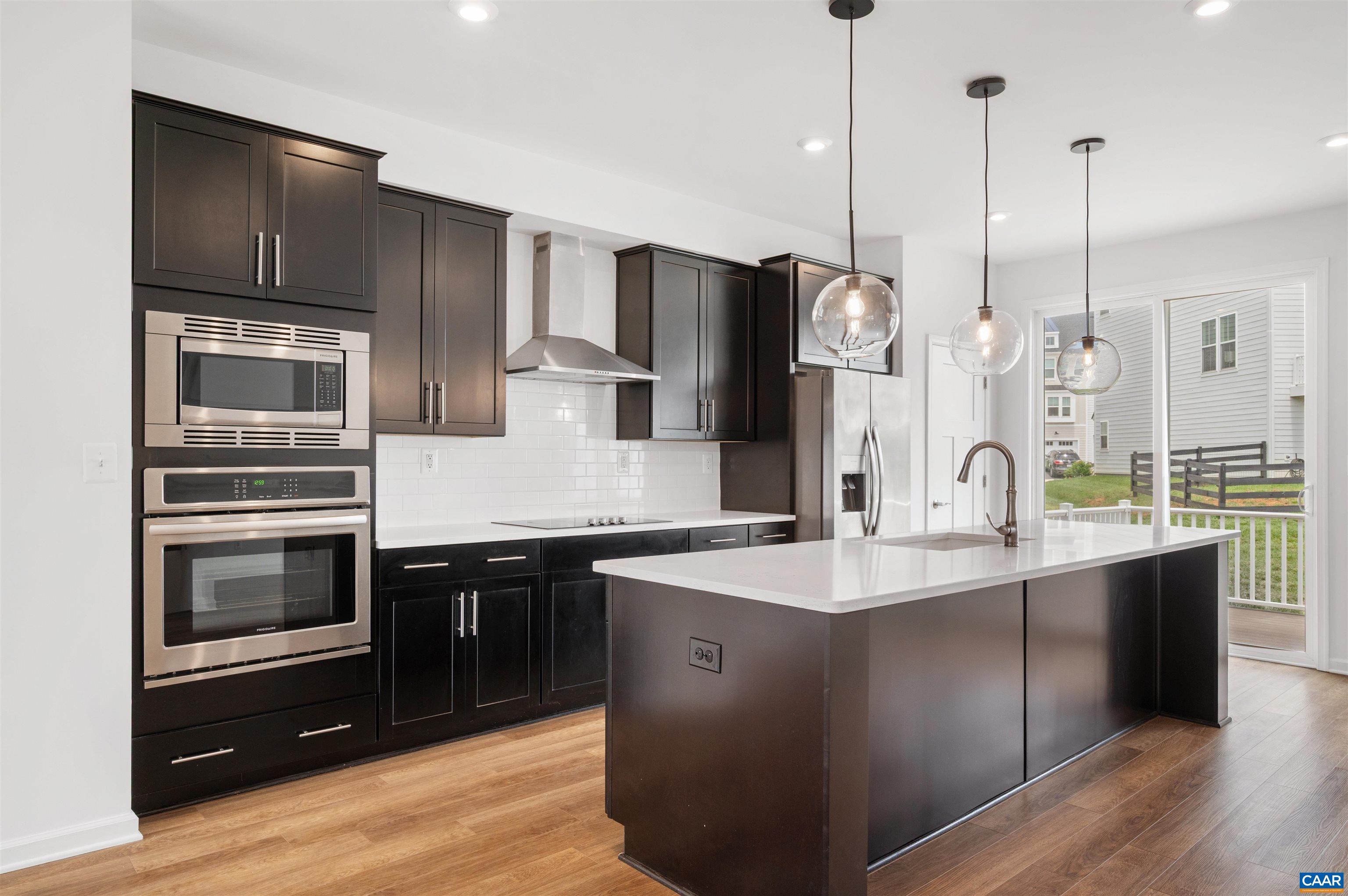 4454 Alston Street Crozet, VA 22932 - Photo 16 of 47 a kitchen with stainless steel appliances granite countertop a sink a stove a refrigerator and island with wooden floor
