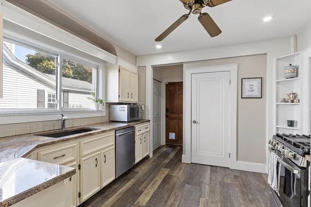 a kitchen with a sink appliances cabinets and a window