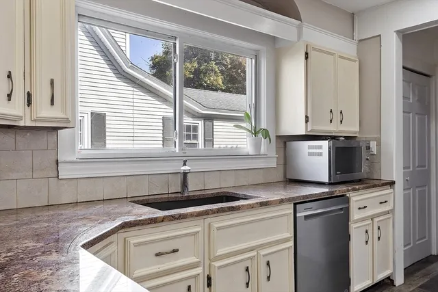 a kitchen with granite countertop a sink cabinets and window