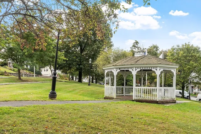 a view of a building with a big yard and large trees