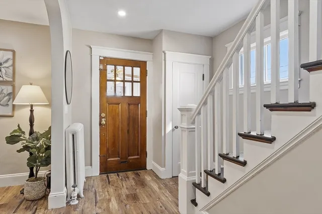 a view of an entryway with wooden floor and front door