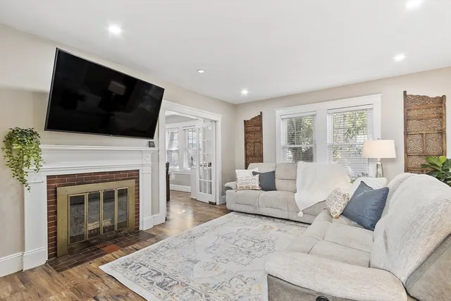 a living room with furniture a fireplace and a flat screen tv