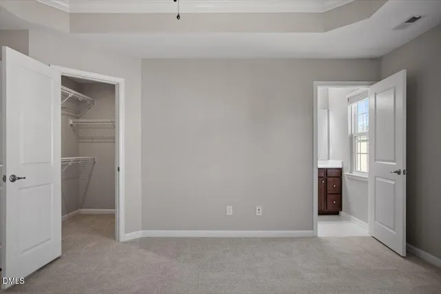 a view of an empty room with closet and a window
