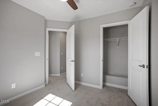 an empty room with closet and windows