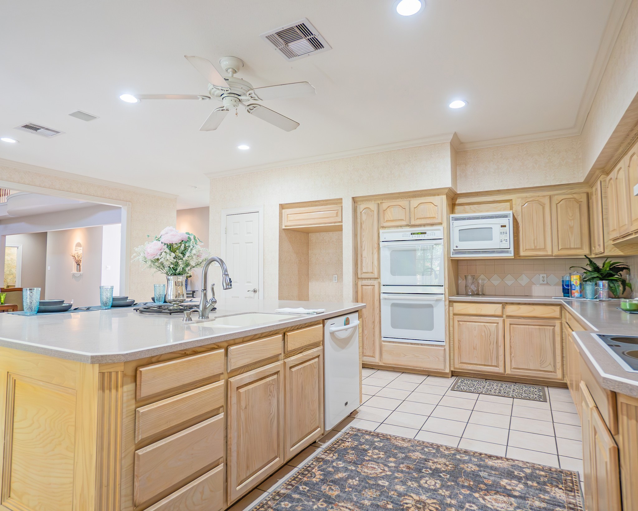 214 Williams Road Bay City, TX 77414 - Photo 31 of 48 a kitchen with a sink dishwasher a stove and white cabinets with wooden floor