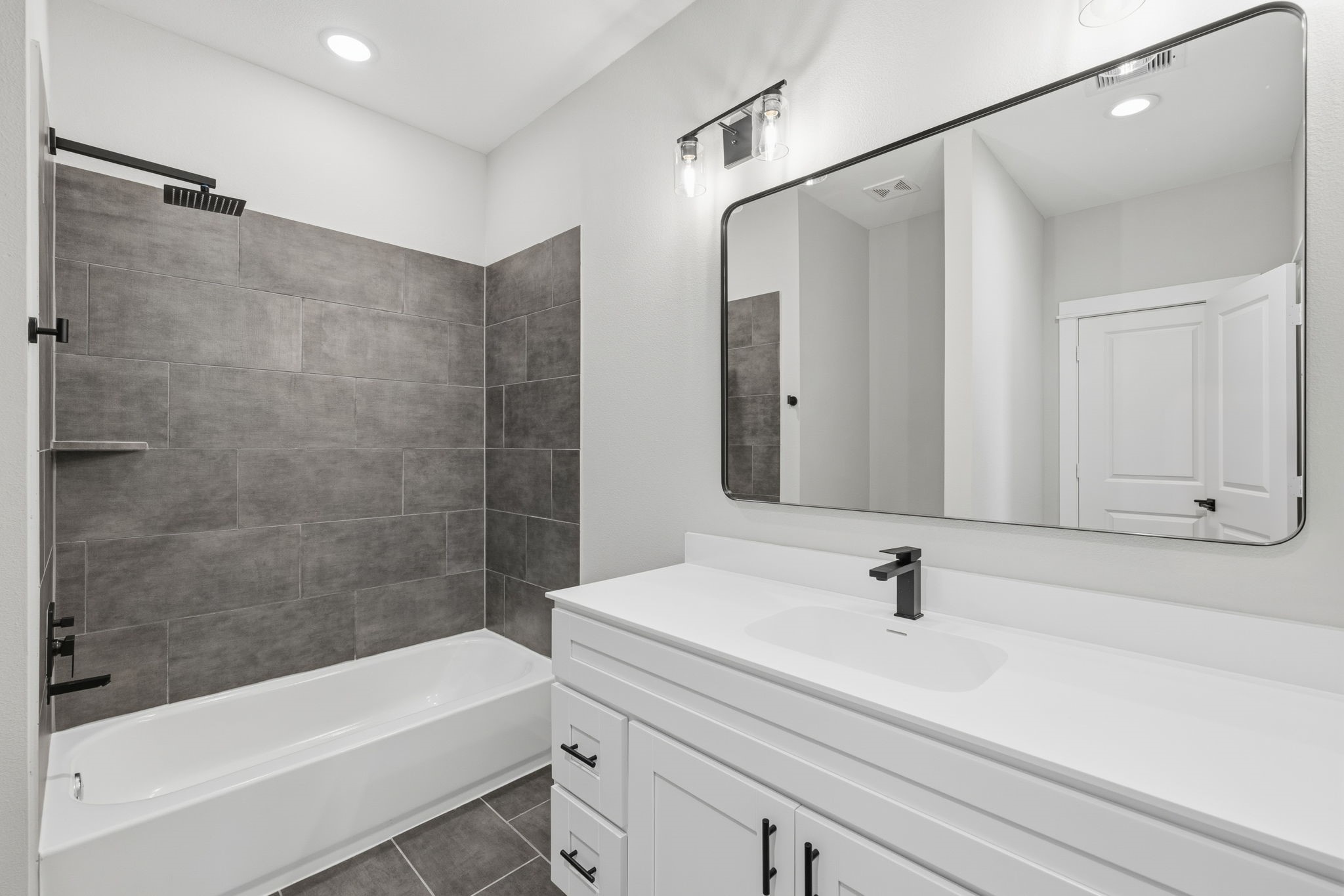 412 Stonework Landing Lane Houston, TX 77076 - Photo 18 of 30 a bathroom with a sink a mirror and a bathtub