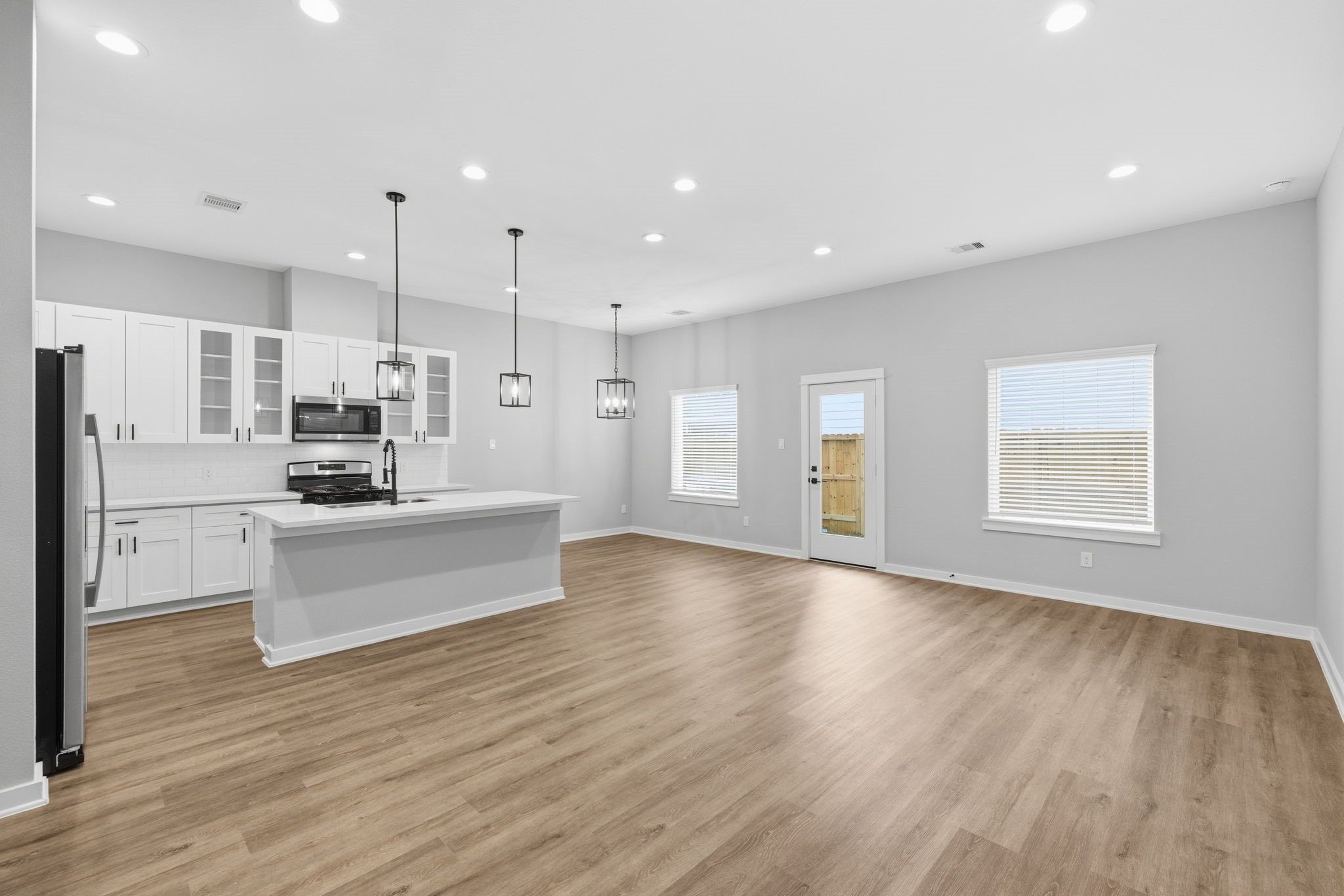 412 Stonework Landing Lane Houston, TX 77076 - Photo 4 of 30 a large kitchen with stainless steel appliances kitchen island a large counter top and a wooden floors
