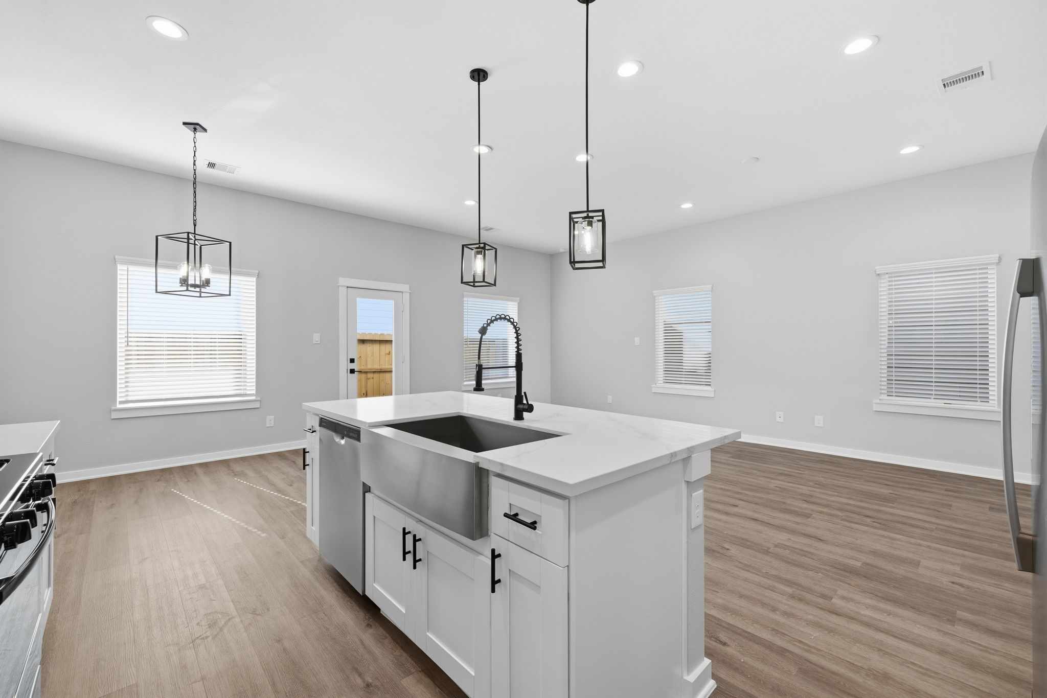 412 Stonework Landing Lane Houston, TX 77076 - Photo 5 of 30 a kitchen with stainless steel appliances granite countertop a sink a window and wooden floor