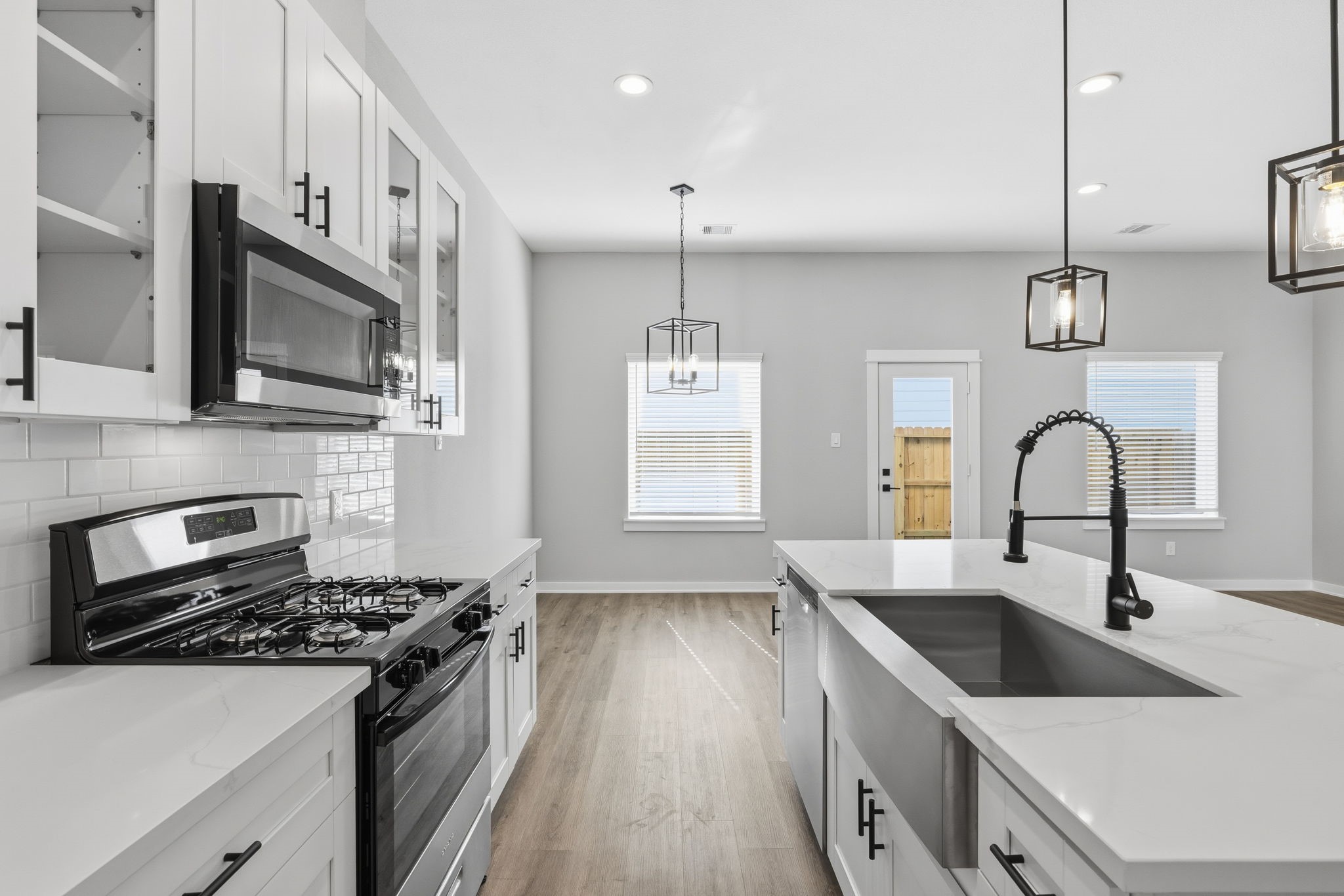 412 Stonework Landing Lane Houston, TX 77076 - Photo 10 of 30 a kitchen with stainless steel appliances granite countertop a sink a stove and a wooden floors