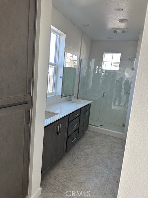 32703 Brunello Way Temecula, CA 92591 - Photo 12 of 26 a bathroom with a double vanity sink toilet and shower